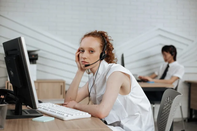 Focused call center agent with headset working at a modern office desk. Creator brand customer service